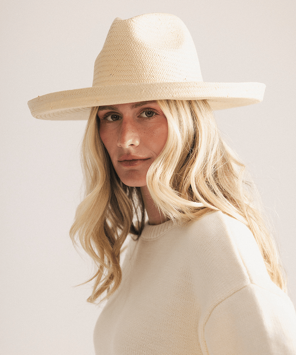 Woman wearing a natural colored pencil brim fedora hat made of paper straw, displayed against a white background. #color_natural