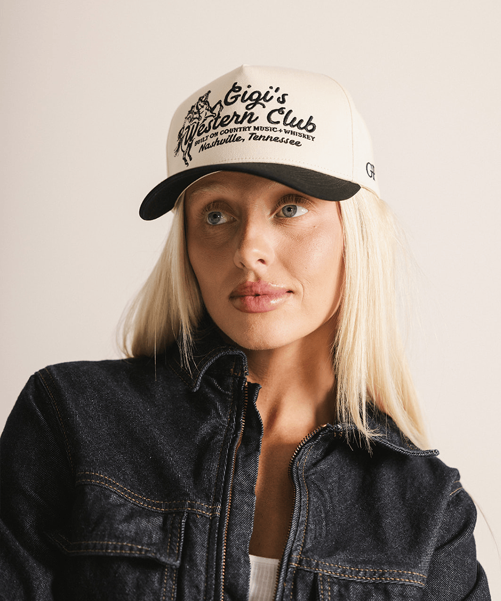 Woman wearing a cap with text and a denim jacket on a plain background #color_cream - black