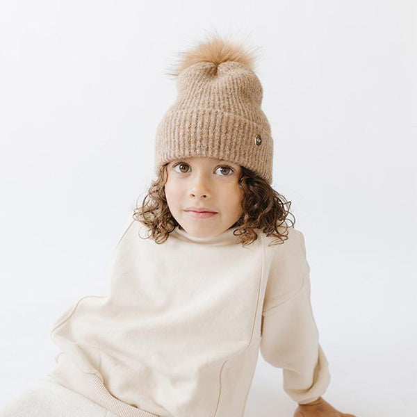 Gigi Pip beanies for kids - Milo Beanie - soft knit ribbers kid's beanie featuring a fold up brim with a rose gold Gigi Pip logo pin on the side of the fold and a pom pom on the center of the crown [camel]