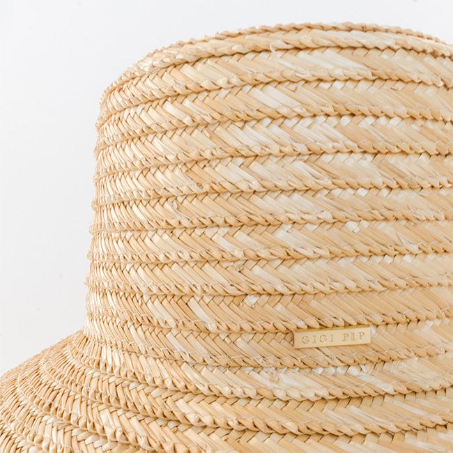 A natural colored boater-style straw hat with the brand label on a white background #color_natural